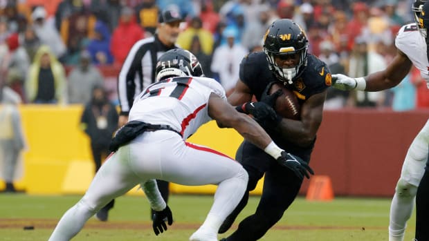 Washington Commanders running back Brian Robinson Jr. (8) carries the ball as Atlanta Falcons linebacker DeAngelo Malone (51) defends during the third quarter at FedExField.